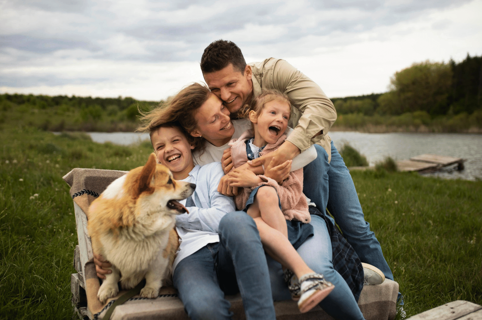 family of 4 smiling with dogs